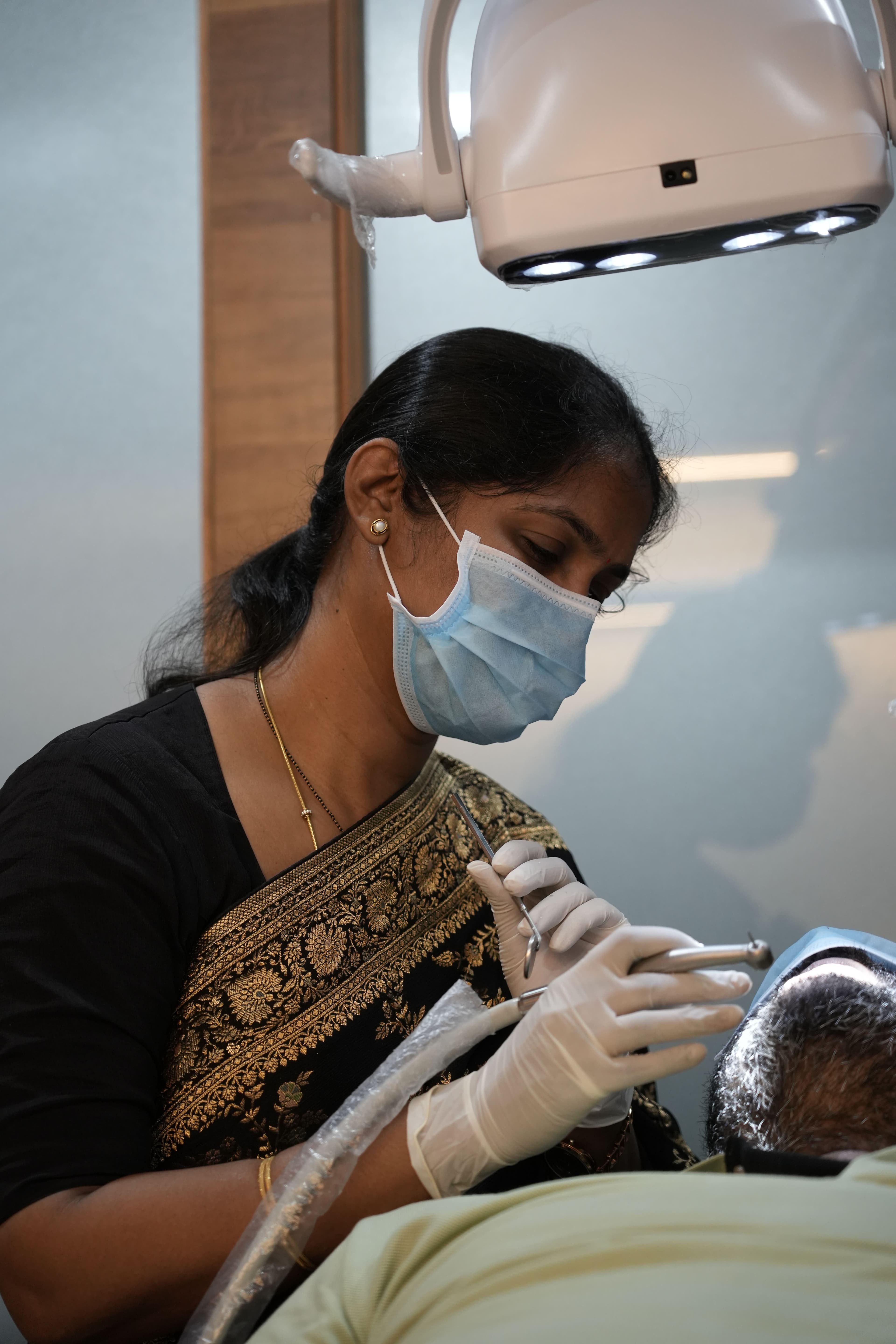 Dr. Siva Nagini treating a patient at Aura Dental